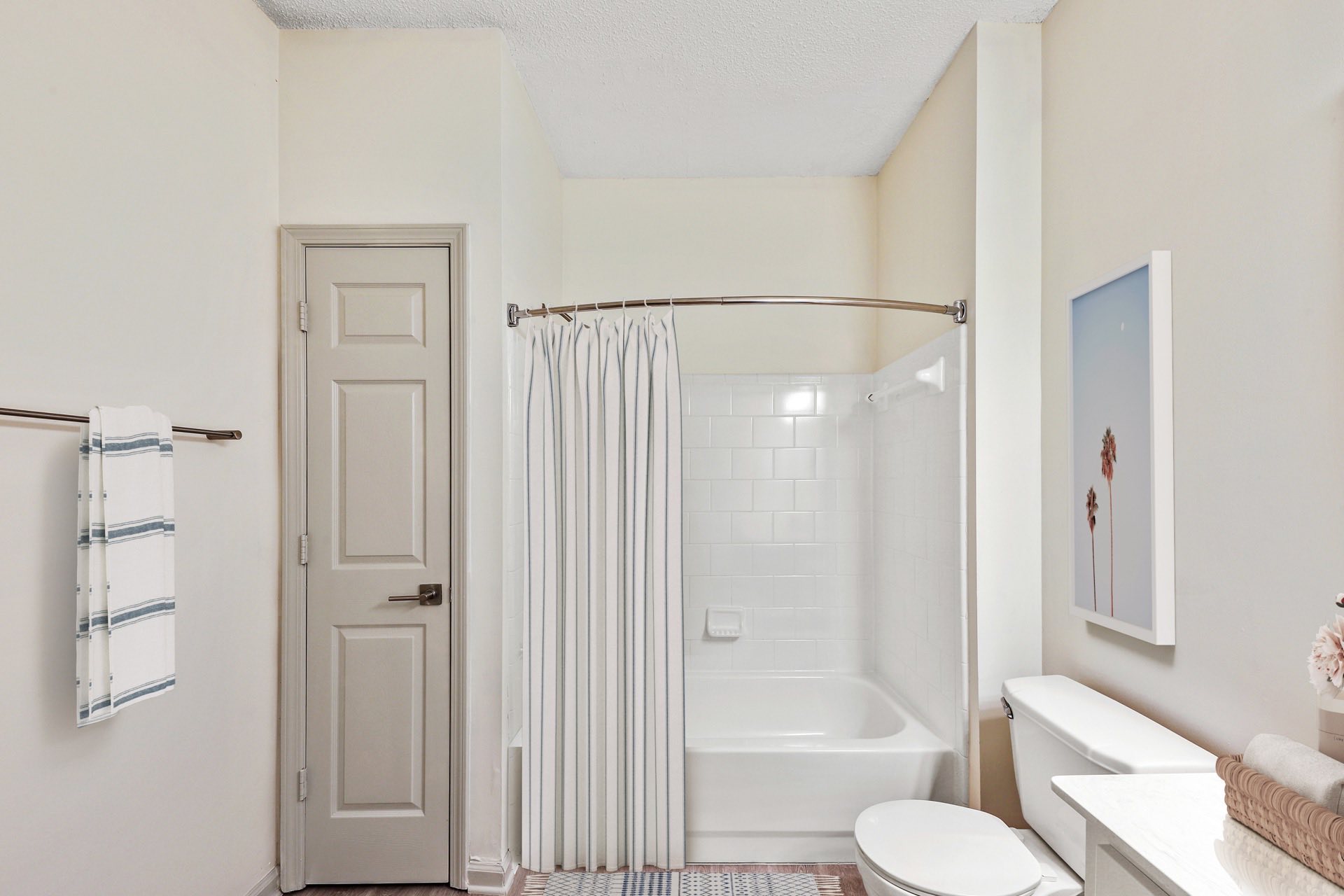 bathroom with curved shower rod and storage closet