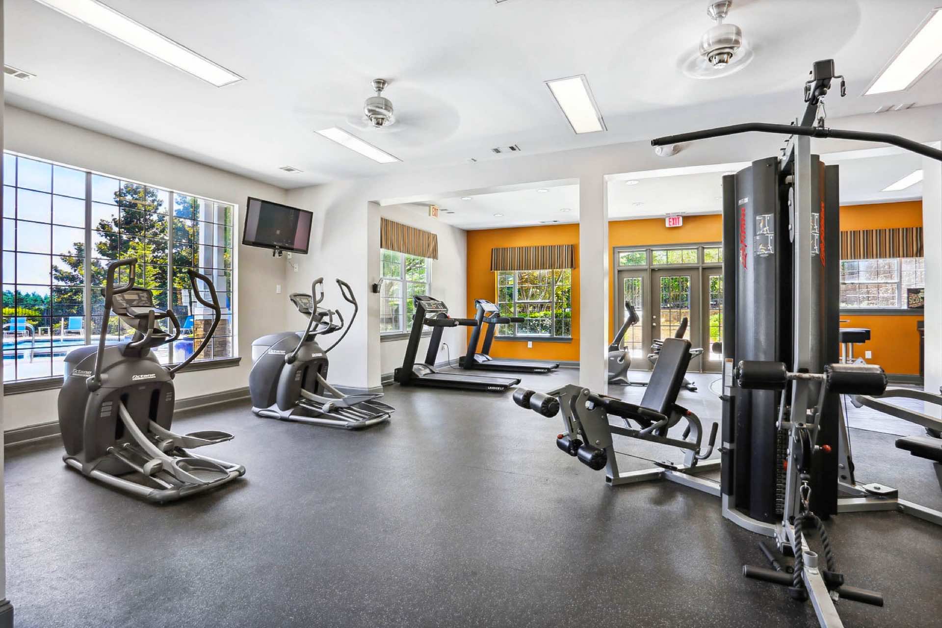 fitness room with ceiling fans and nearby pool