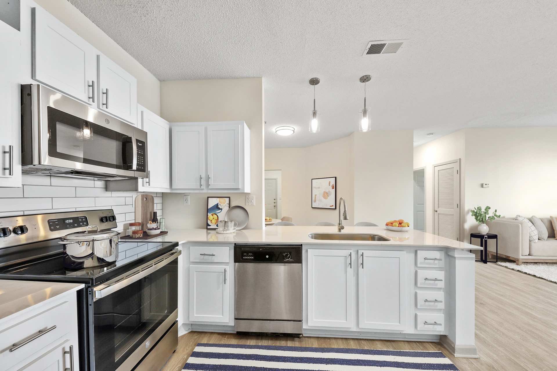 updated kitchen with stainless steel appliances and wood-style flooring leading to open floor plan layout